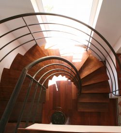 Escalier 2/4 tournant balancé avec limon central, supports de marches en métal, marches en bois exotique