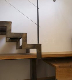 Escalier avec bureau métal et bois à crémaillère. Création sur-mesure pour aligner le plan de travail du bureau avec la hauteur de la marche. Créé par Atmos Fer, ferronnerie contemporaine à Toulouse.