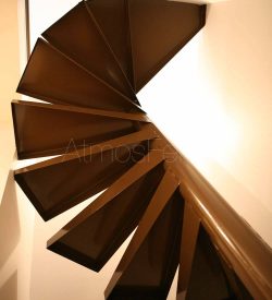 Escalier colimaçon en métal plié en tôle peinte. Garde corps de l’étage en tube rond avec une partie basse en tôle ajourée - Crédit photo Laurent Barranco